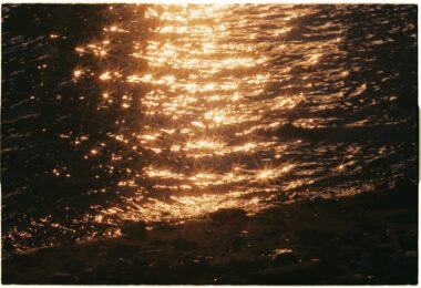 gold reflection of the water by the beach in the sunset